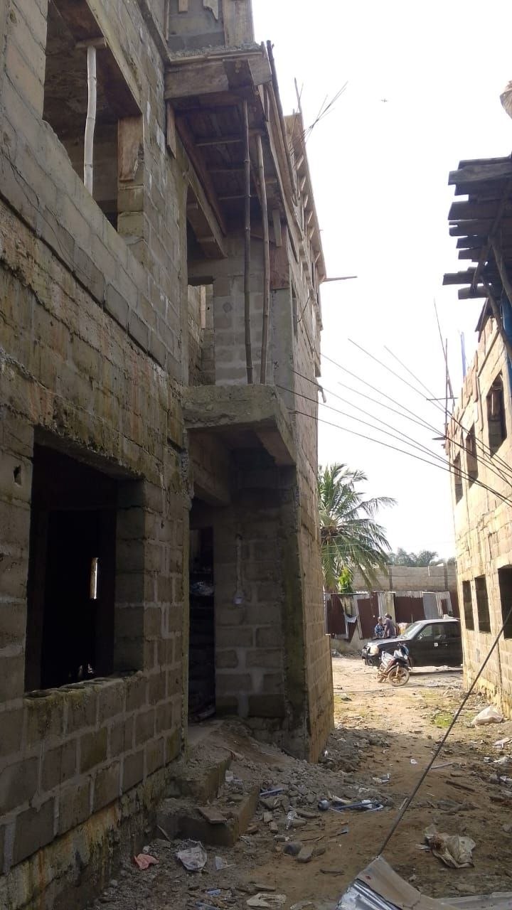 Two-storey sandcrete block walls in progress